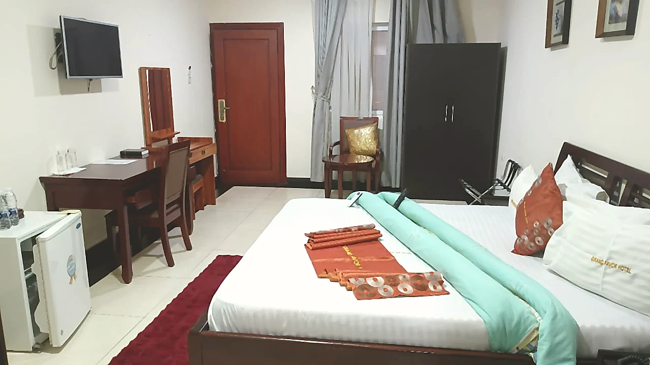 Executive room with work area, wardrobe, and king bed at Grand Favor Hotel