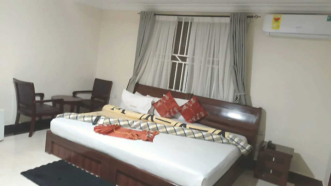 Grand King Window Room with bed and curtain backdrop at Grand Favor Hotel