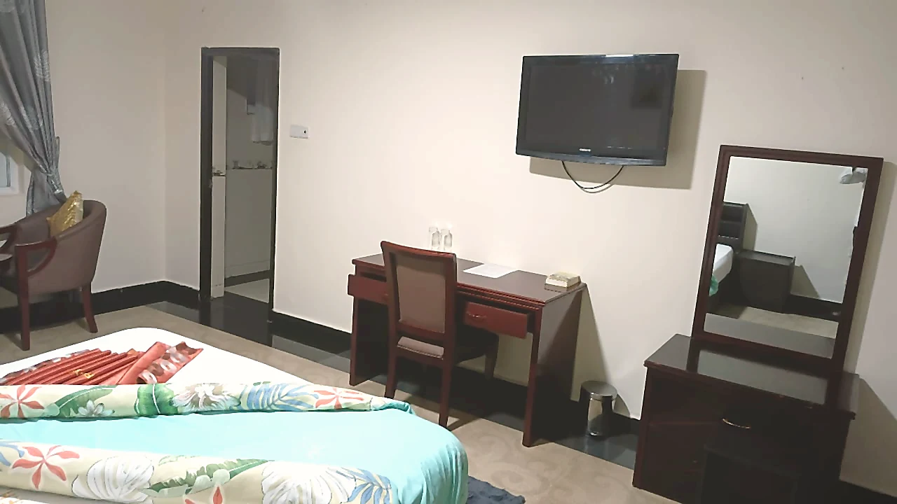 Guest room desk and mirror with bed at Grand Favor Hotel
